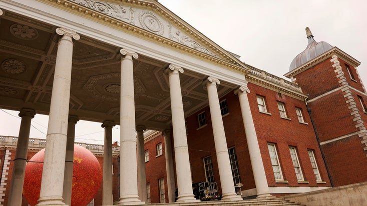 Luke Jerram's bright orange Helios seen through the portico at Osterley Park